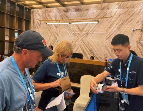 圖:工商銀行工作人員指導外籍參賽運動員注冊繳費 圖:工商銀行工作人員指導外籍參賽運動員注冊繳費